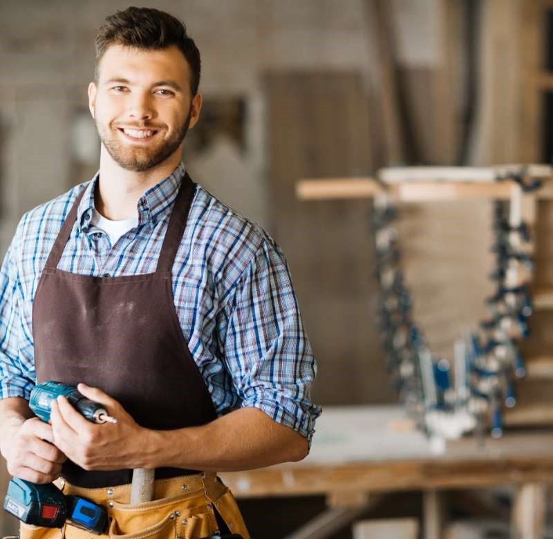 carpenter wearing apron & holding drill